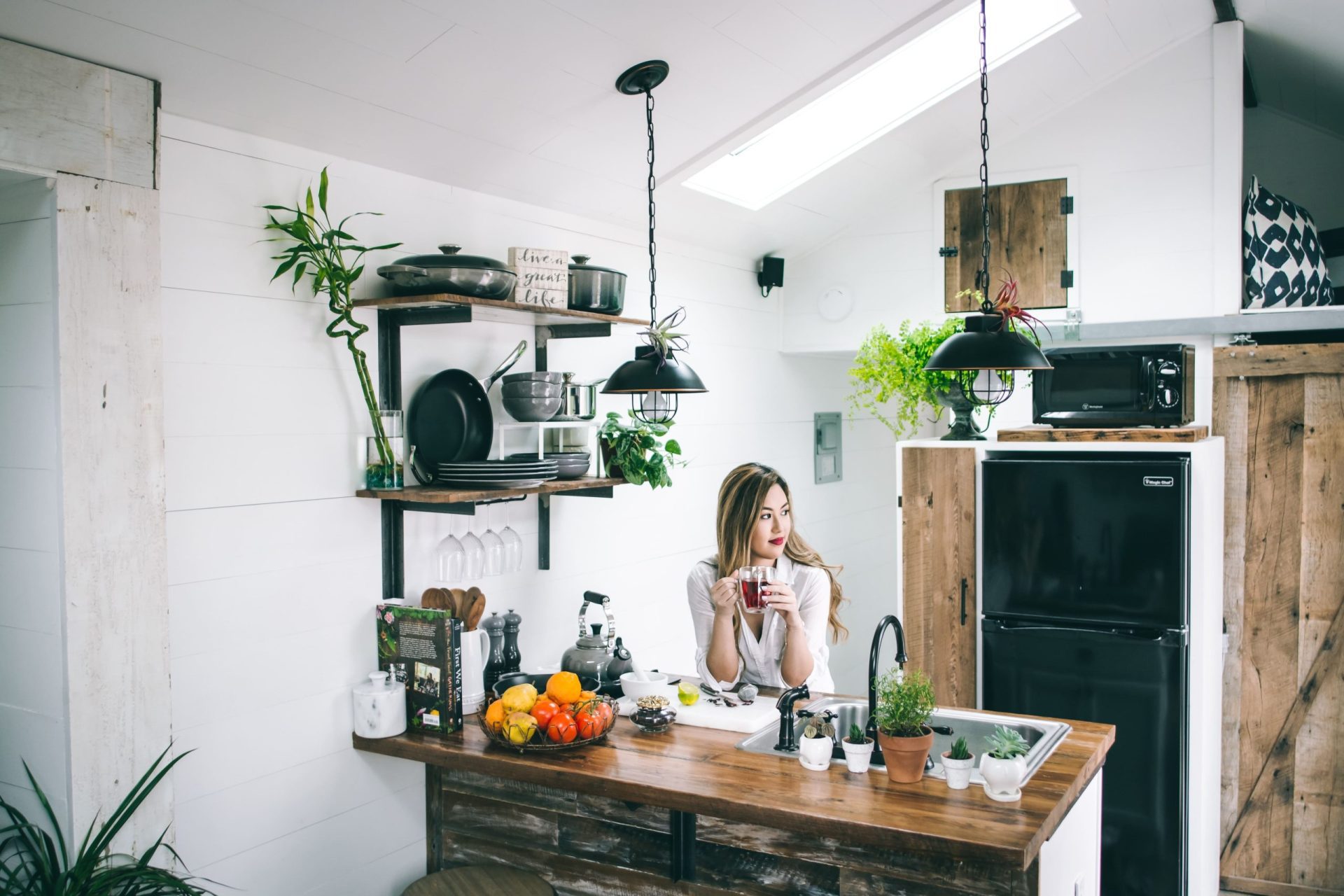 Moving Home Mortgages | Woman in a kitchen enjoying a herbal tea surrounded by plants